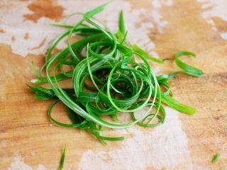 9、鲜美无比的粤式清蒸鲈鱼,把葱叶用牙签划成细丝后，用盐水浸泡一会儿。