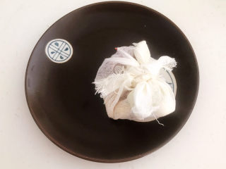 6、白切羊肉,把羊肉料包和葱姜用纱布抱起来,料包做好了备用