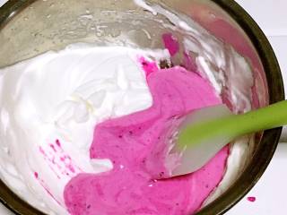 6、火龙果溶豆,把翻拌好的火龙果糊倒入剩下的蛋白霜中。用上下切拌的手法拌匀。