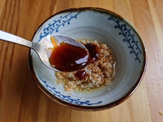 6、蒜蓉蒸丝瓜,加入一勺蚝油拌匀备用。