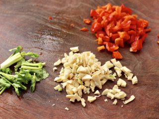 2、蒜香手撕包菜粉条,大蒜去皮切碎，红椒切碎，香菜切段。