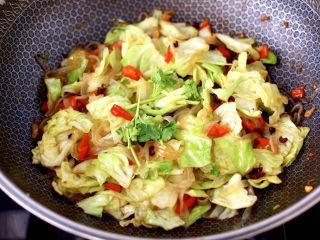 14、蒜香手撕包菜粉条,大火快速翻炒均匀，撒上香菜段即可关火。