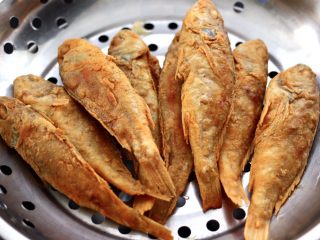 13、五香干炸大头宝鱼,炸好的大头宝鱼，放到油盘里沥干油分。