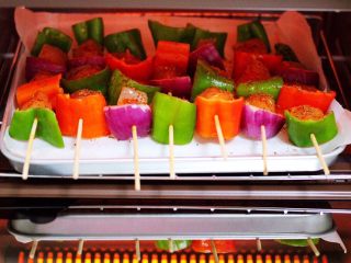 11、时蔬孜然烤鸡肉串,九阳LINE FRIENDS烤箱提前200度预热10分钟后，把串好的鸡肉串放到烤箱里。