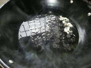 2、云吞汤面,油锅加碗水、1勺盐、蒜瓣、大火煮开后。