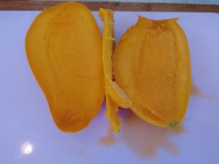 2、百香果+芒果苹果汁,芒果从中间切开,去葫。(如图)