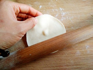 13、韭菜盒子,将面剂子按扁，擀成边缘薄中间略厚的圆皮。