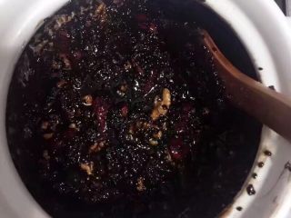 3、纯手工自制阿胶糕,再放入核桃仁搅拌均匀，最后再分两次放入黑芝麻和蜂蜜后，可以直接关火搅拌，这样就不会糊锅。