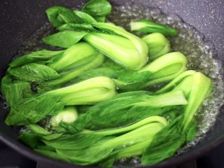 3、年夜饭必备的香菇油菜,锅中倒入适量的清水，加入少许盐和几滴食用油，大火烧开后放入油菜进行焯水，看见油菜断生变色即可捞出沥干水分。