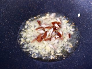 5、年夜饭必备的香菇油菜,锅烧热后，倒入花生油烧热，先放入大蒜碎爆香，再放入香菇碎，大火快速翻炒片刻。