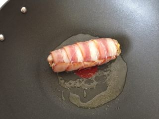 11、培根奶酪鸡肉卷,放入腌制好的鸡肉卷，煎至培根上色收紧，中途不断翻面使受热均匀。