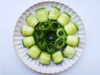 3、响油黄瓜卷,将黄瓜片从一头卷成卷码入盘中。