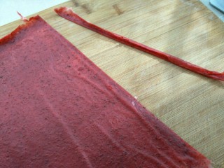 9、自制果丹皮,封干好后，托油纸，去边，切宽条就可以卷起来啦～