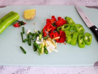 2、辣爆花蛤,把青椒和红椒用刀切条，葱姜切成丝。