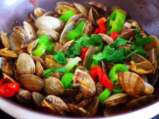 11、辣爆花蛤,大火翻炒至花蛤口都张开，青椒和红椒断生变色的时候，撒上香菜段即可关火。