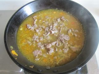 11、酸汤肥牛,将肥牛再放入里面焯烫一分钟捞出放在金针菇的表面上;