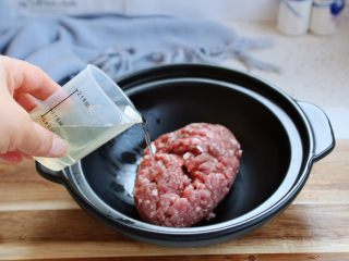 6、冬瓜羊肉丸子汤,分多次倒入花椒水，将花椒水与羊肉末搅拌均匀。