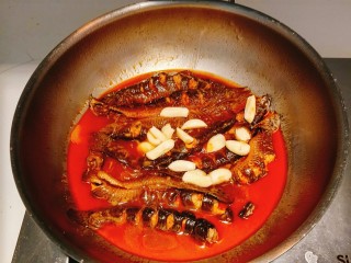 12、红烧泥鳅,倒入大蒜，炖十分钟！