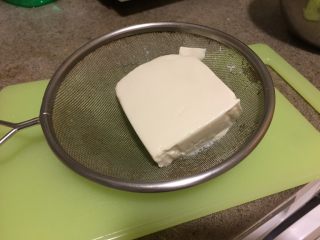 2、日式蔬菜拌豆腐,捞出豆腐,沥干水分,用吸水纸包裹上,吸干水分,放凉。