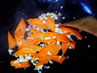 6、荷兰豆海鲜豆芽小炒,这个时候加入胡萝卜片，放到锅里小火慢慢煸炒。