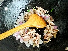 4、洋葱爆猪肚,倒入洋葱和猪肚翻炒均匀。