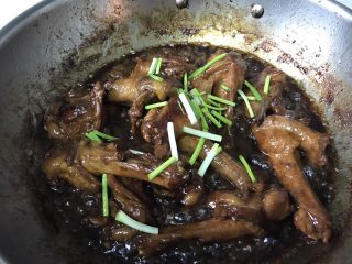 12、酱烧鸭翅根,慢慢收干到出油状态以后，撒香葱翻拌几次即可关火。此时鸭翅根有一点缩小，鸭肉的油脂已经析出，盛出的时候只要将鸭翅根盛出装盘即可！油可以过滤好了，烧别的菜用。