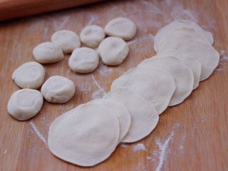 11、猪肉酸菜馄饨,把剂子摁扁后，用擀面杖擀成圆形薄面皮。
