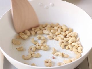 8、绿色美食+腰果西芹开胃炒,热锅冷油放入腰果，将腰果不停翻炒，小火炸至金黄。