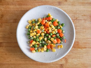 1、八宝百财福袋,胡萝卜去皮切小丁后和青豆，甜玉米粒一起过水焯一下。