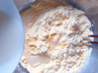 4、玉米面红枣包,加入酵母水，边加边用筷子搅拌成絮状。