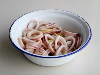 2、双椒炒鱿鱼卷,鱿鱼卷反复洗几次，加入料酒、醋、姜片、半勺盐腌渍10几分钟；
