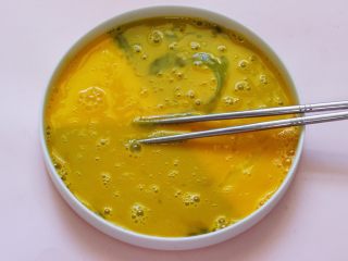 2、椰香黑芝麻吐司条,把鸡蛋打入一个深一点的盘子里，用筷子打打散后。