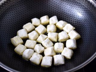 9、酱香包浆豆腐,锅烧热后倒入花生油烧热，放入包浆豆腐小火慢慢煎至。