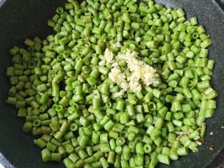 9、肉末豆角,煸炒至豆角变色表皮微黄时加入蒜末翻炒均匀。