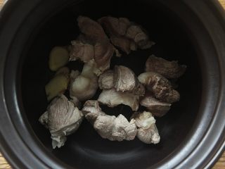 8、青红萝卜煲猪腱汤,将猪腱肉、蜜枣、陈皮连同姜片一起放入汤煲内;
