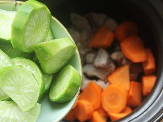 9、青红萝卜煲猪腱汤,放入切好的胡萝卜和青萝卜;