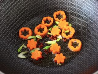 8、虾仁清炒西兰花便当,把焯过水的胡萝卜放入锅中，大火翻炒片刻。