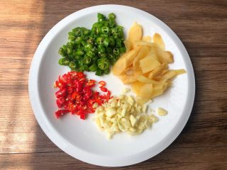 4、香辣牛蛙,泡姜冲洗一下切片，青辣椒和小米辣清洗干净切成圈圈，蒜头去皮洗净切蒜末。