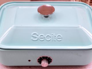 15、紫薯酸奶果仁芝麻饼,盖上锅盖小火慢慢煎至。