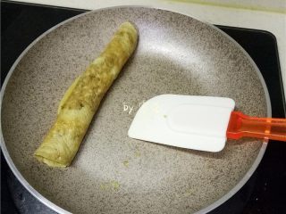 9、香椿厚蛋烧,蛋液即将凝固时，借用刮刀将蛋饼从一头卷至另一头；