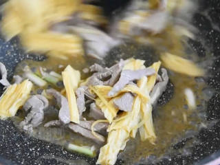 5、又一道下饭利器,营养丰富且简单易学,炒至变色倒入腐竹,加入1勺生抽、小半杯清水大火翻炒。