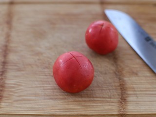 2、番茄肉酱意面,番茄洗净后在表面划十字
