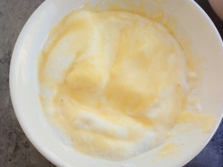 14、松软可口~戚风蛋糕(六寸版),取出1/3的蛋清和之前拌好的蛋黄混合,用橡皮刮刀切拌均匀