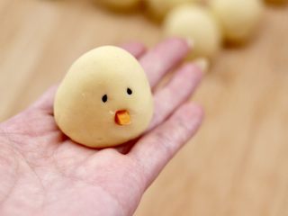 10、小鸡窝窝头,取两颗黑芝麻粘在面团上,作为小鸡的眼睛,再用刻好的胡萝卜做小鸡的嘴巴。