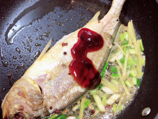 9、酱焖黄花鱼,放入料酒、蚝油。