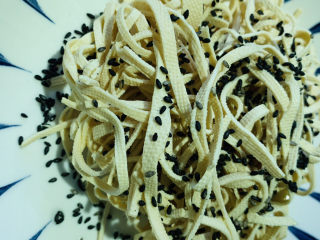 10、凉拌千张,千张沥干水，盛盘里，撒上熟芝麻