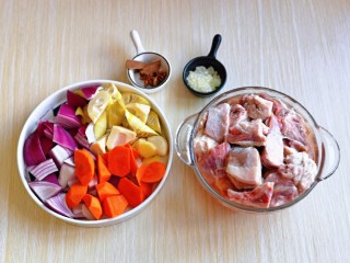 1、红烧羊排,准备食材，羊排剁小块泡冷水，将血水泡出，胡萝卜去皮洗净切菱形块，洋葱去皮切小块，雷笋去皮切菱形块，葱姜蒜切好。