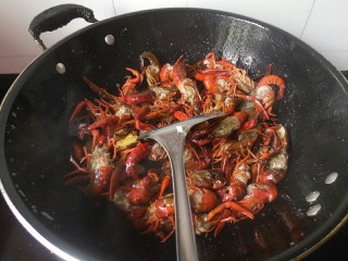 6、麻辣小龙虾,翻炒一分钟左右后，加入尖辣椒、生姜、蒜、花椒，继续翻炒！