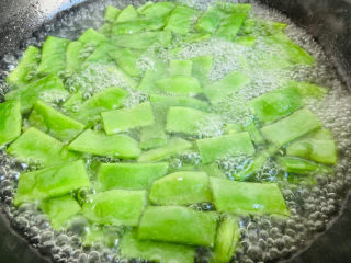 8、爆炒豆角,倒入豆角焯烫至断生