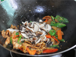 8、双椒花菇炒肉片,将汆烫好阿德花菇片倒进去一起翻炒至上色。